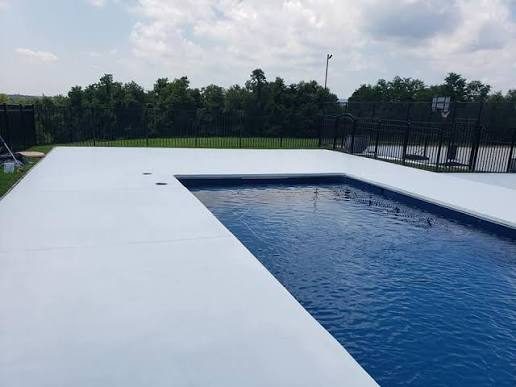 Light gray pool deck around a dark blue pool